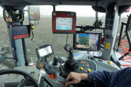 Modern farming tractor using GPS technology to plant potatoes in an agricultural field.